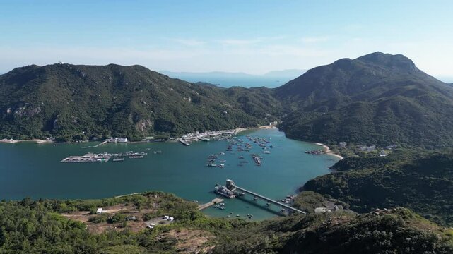 Aerial drone footage of the Sok Kwu Wan village that is famous for its seafood restaurants row and ferry pier in the Lamma island in Hong Kong.