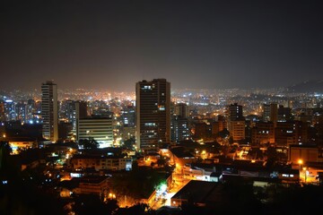Fototapeta premium City skyline illuminated at night showcasing vibrant buildings and forested foreground