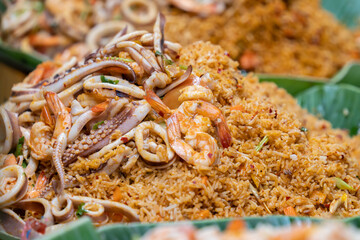 Close-up view of fried rice. The rice is perfectly stir-fried, combined with succulent shrimp, squid, tender octopus, and vegetable.