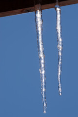 屋根の下に伸びる美しい氷柱