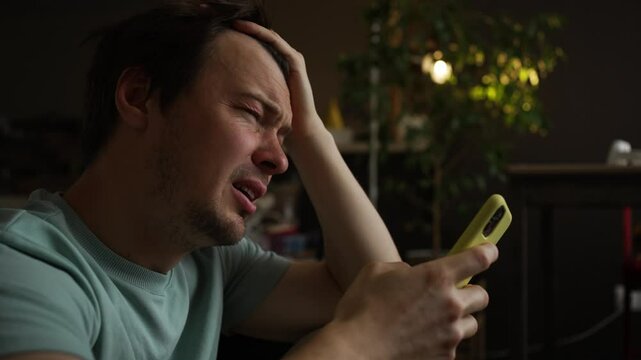 Sadness and despair overwhelm a man as he receives devastating news on his smartphone, tears streaming down his face as he processes the information