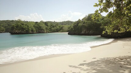 Obraz premium Secluded tropical beach cove with gentle waves and lush green foliage surrounding white sand beach