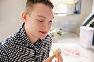 Teenage boy anticipates eating delicious cupcake