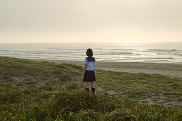 海を見つめる女子高校生の後ろ姿