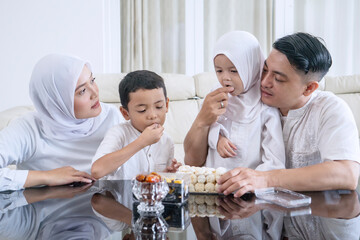 Muslim Family Enjoying Traditional Sweets and Dates During Ramadan or Eid Celebration
