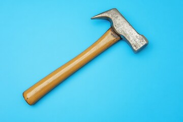 Metallic hammer with wooden handle lies on a blue background