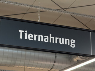  Schild Tiernahrung über Regal der Warengruppe in Supermarkt mit Katzenfutter und Trockenfutter, Abteilung Heimtierbedarf und Haustier-Futter am Point-of-sale POS 