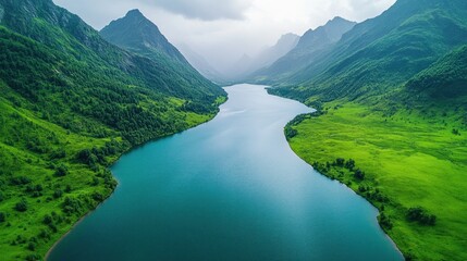 Fototapeta premium Alpine lake nestled in lush valley, aerial view