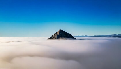 A single mountain peak rising above a sea of thick fog