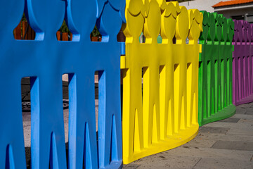 Fototapeta premium A row of colorful plastic figures are lined up in a row. The figures are of different colors and sizes, and they are all facing the same direction. Concept of unity and togetherness