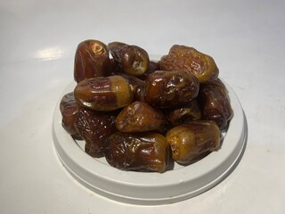 Pile of delicious dried dates isolated on white background from side angle. Arabic food