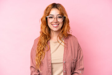 Young caucasian woman isolated on pink background With glasses with happy expression