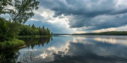 Fototapeta premium Serene Lake Landscape Under Dramatic Clouds and Reflected Sky