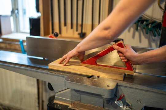 Unrecognizable carpenter woman hand working with woodworking machine, straightening and cutting boards for future furniture. Crafted workshop tools, jointer hands and manual labor, woodcraft, DIY