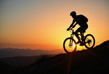 Mountain Biker Silhouette Riding at Sunset with Scenic Mountain Views
