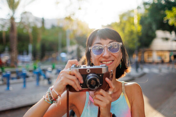 girl taking pictures. Girl walking around the city taking pictures with a camera. young girl with a film camera in the city.  Close-up of a film camera.