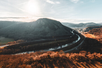 Steilhang mit Blick ins Tal, Fluss und Straße unter blauem Himmel