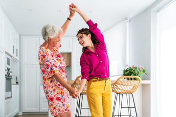 Beautiful grandmother and granddaughter together at home - Cheerful granma and nephew spending...