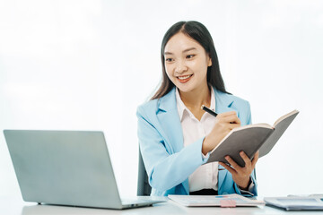 An Asian female accountant works happily at her desk in the office, using a laptop to analyze financial charts. She manages business finance and online transactions for company success