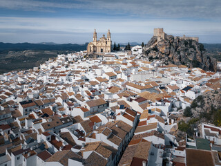 Catholic cathedral and ancient castle on hill top above ancient white town, Olvera, Andalusia, Spain