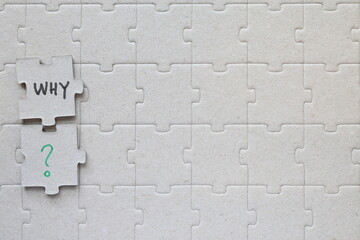 Gray puzzle concept with the word WHY.
