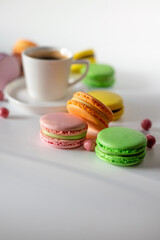 A charming display of macarons in various colors with a cup of coffee, perfect for a sweet afternoon treat