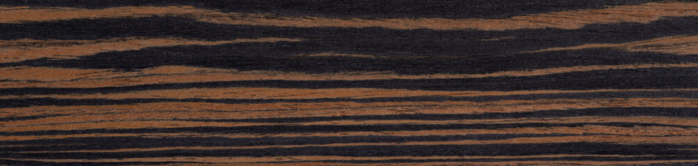 Vivid tiger-striped patterns of burnt sienna weave through the midnight allure of this macassar ebony veneer