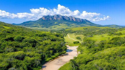 Panoramic View Of Dry Riverbed Winding Through Lush Green Landscape And Mountains