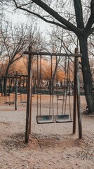 Fototapeta premium Quiet Autumn Evening at Swing Set in Empty Park with Bare Trees