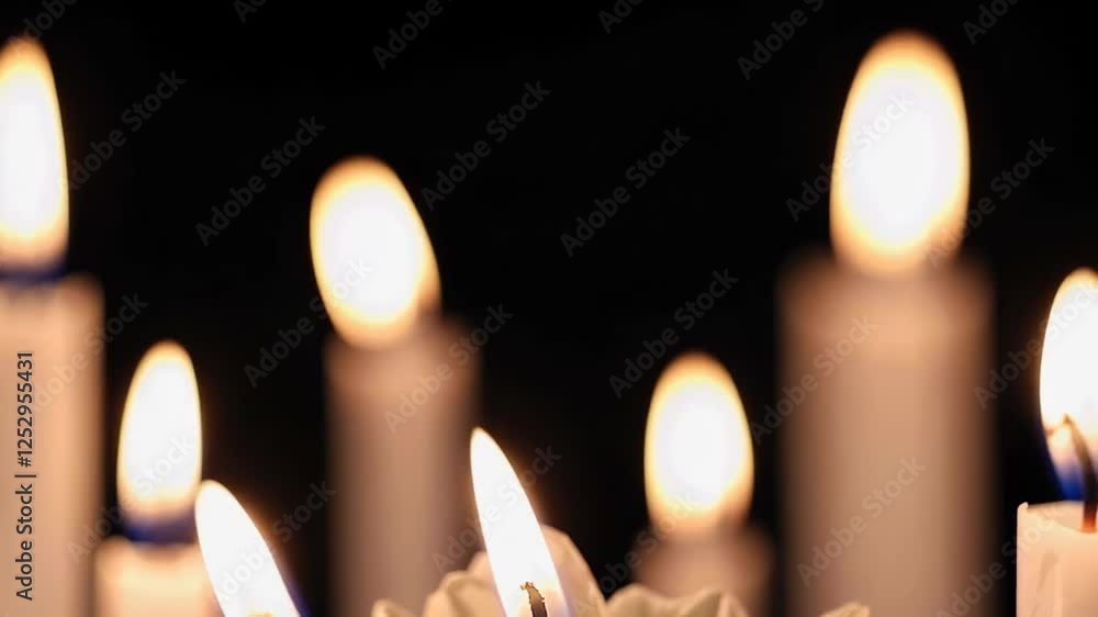 Poster candles glowing softly in dark setting with flickering flames
