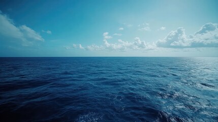 Obraz premium Serene Ocean Vista: A boundless expanse of deep blue water under a bright sky, inviting tranquility and peace.
