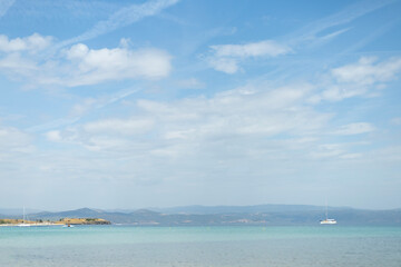 picturesque coast view of the magically azure surface of the sea from the shore