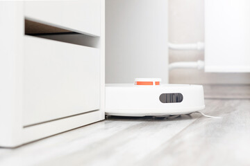 robot vacuum cleaner cleans the floor in the office. robot vacuum cleaner comes out from around the corner. robot vacuum cleaner cleans under the table. office cleaning 