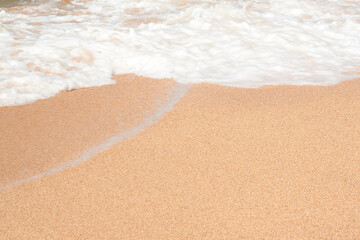 Wave hits the sandy beach