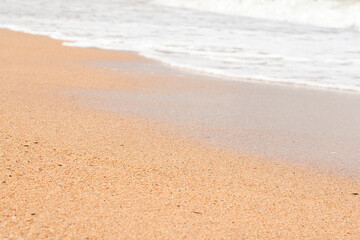 Wave hits the sandy beach