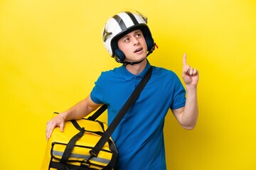 Young Brazilian man with thermal backpack isolated on yellow background thinking an idea pointing the finger up