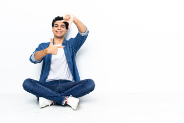 Venezuelan man sitting on the floor focusing face. Framing symbol