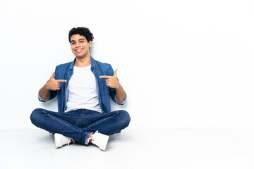 Venezuelan man sitting on the floor proud and self-satisfied