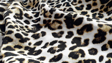 Leopard print. Lightweight natural fabric for summer clothing with an animal print. Viscose. Cotton. Cotton fabric texture. Textile background.
