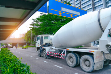 Cement mixer truck driving on highway at junction in city
