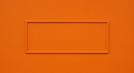 Vibrant orange wall featuring a blank rectangular frame, ideal for creative displays or signage