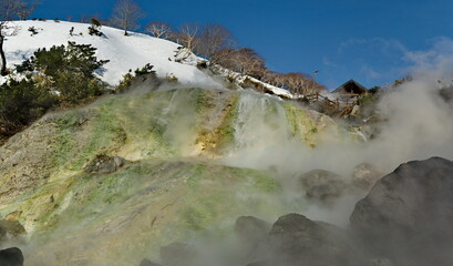 Russia. Kuril Islands. The bed of the thermal spring (Boiling River) near the Baranovsky volcano has a picturesque bright emerald color. The temperature of the water in the baths reaches 40 degrees.