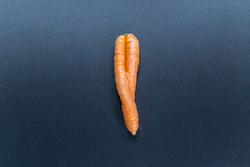 Crooked carrots on black background from organic farmer as symbol for couple in love and...