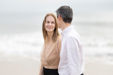 Couple walking on the beach, enjoying a romantic stroll by the ocean