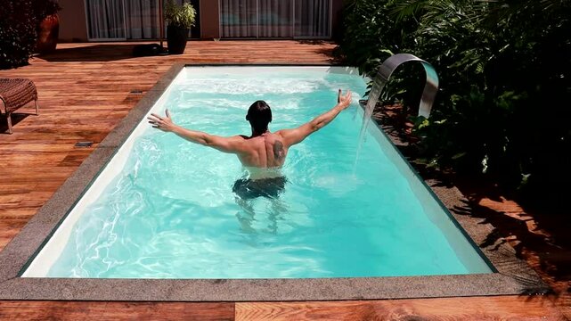 homem na piscina no ver&atilde;o 