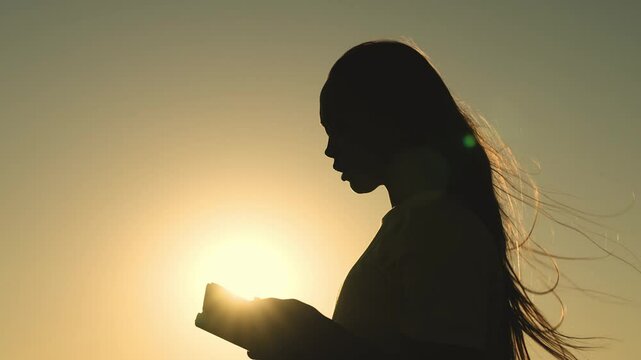 girl prays with bible her hands sunset. young girl asks for help. read prayer dawn. human faith dream. ask sky. relaxation concept. happy person lives faith. good book helps find way. pray park sun