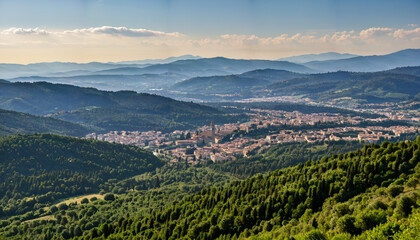 Obraz premium Paysage montagneux verdoyant avec une ville au centre