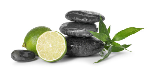 Spa composition with limes, massage stones and green leaves isolated on white
