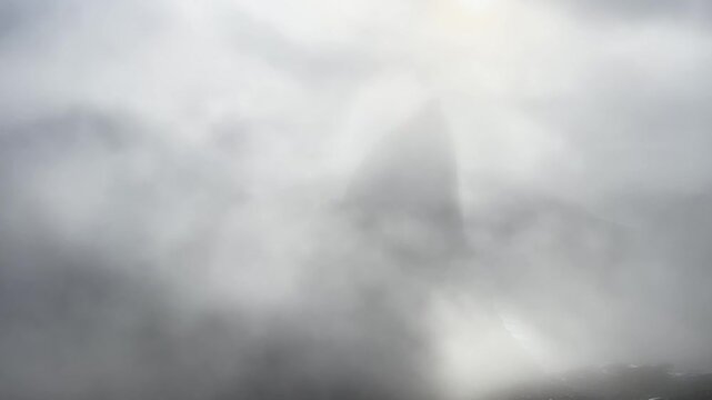 Fog is surrounding a Segla peak over the ocean in Senja, Norway