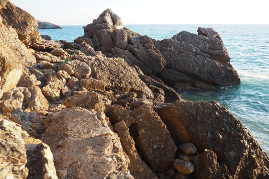 Waves gently crash against the rugged rocks while the sun sets over the horizon. Experience the serene beauty of this coastal location filled with natural wonders. Canj, Montenegro, Adriatic sea